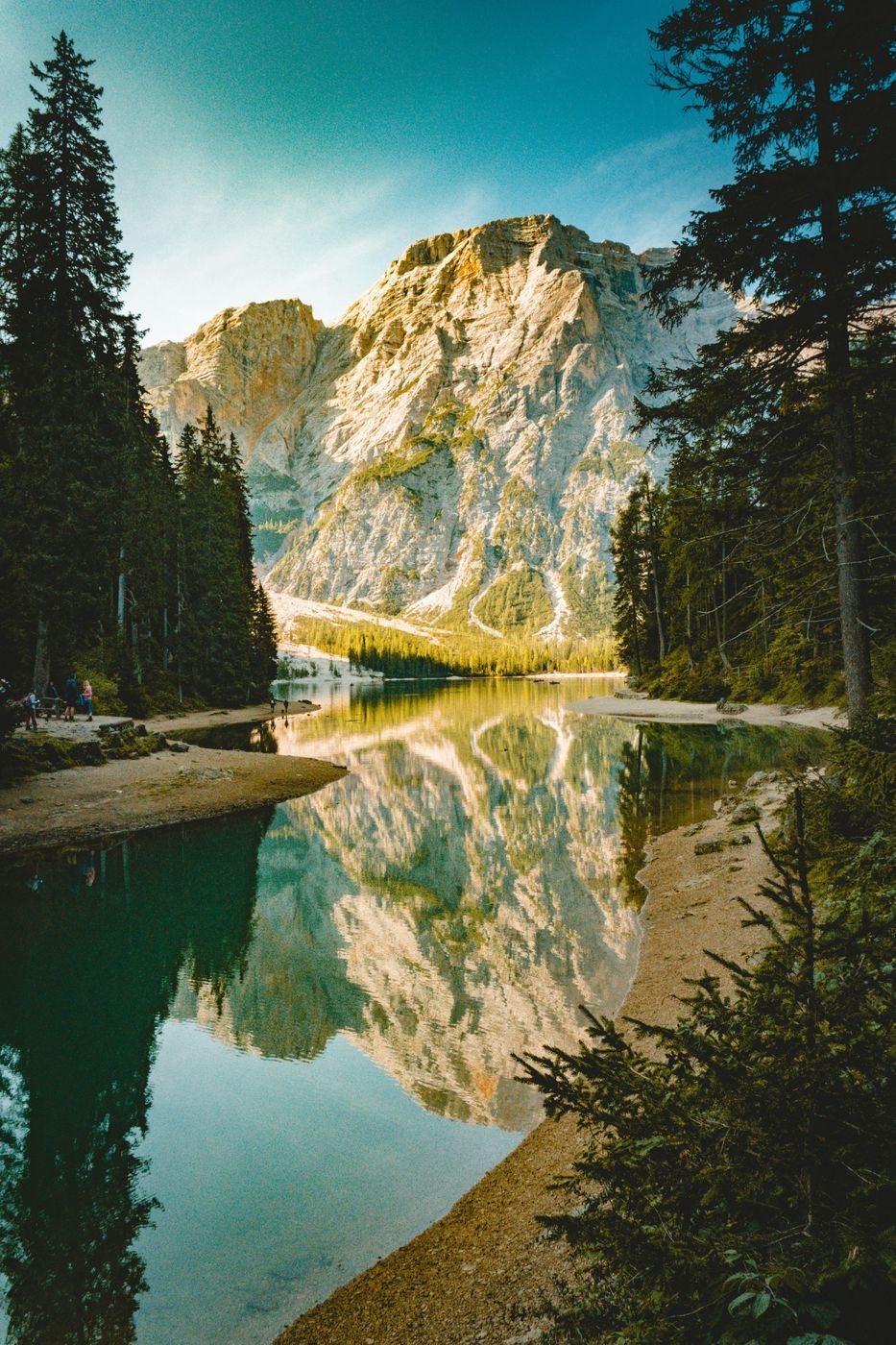 Lago de montaña con reflejo de los picos