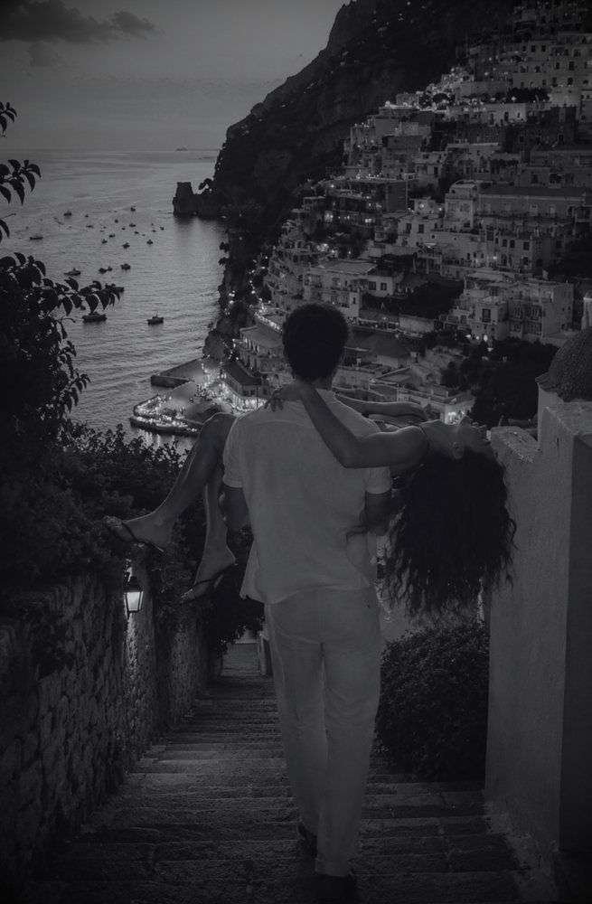 Pareja en una escalera frente al mar, en blanco y negro